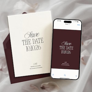 Può includere: Elegante set di inviti di nozze con un biglietto color crema con la scritta "Save the Date 10.10.26" in un carattere elegante, accompagnato da una busta bordeaux abbinata. Uno smartphone mostra lo stesso design.