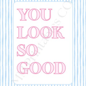 May include: A decorative print with a light blue and white striped background. The print features the words "YOU LOOK SO GOOD" in pink letters inside a white rectangle.