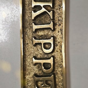 Letrero de puerta de latón