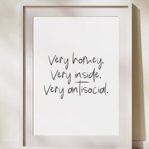 Puede incluir: Impresión artística enmarcada en blanco con texto manuscrito en negro. El texto dice: "Muy hogareño. Muy adentro. Muy antisocial."