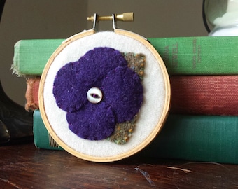 Aplique de flor roxa em bastidor de bordado