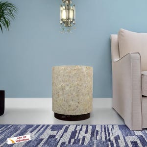 May include: A cylindrical side table with a textured, off-white surface and a dark brown base. The table is approximately 46 cm tall and sits on a patterned blue and white rug. The text "ART OF Rajasthan" is visible.