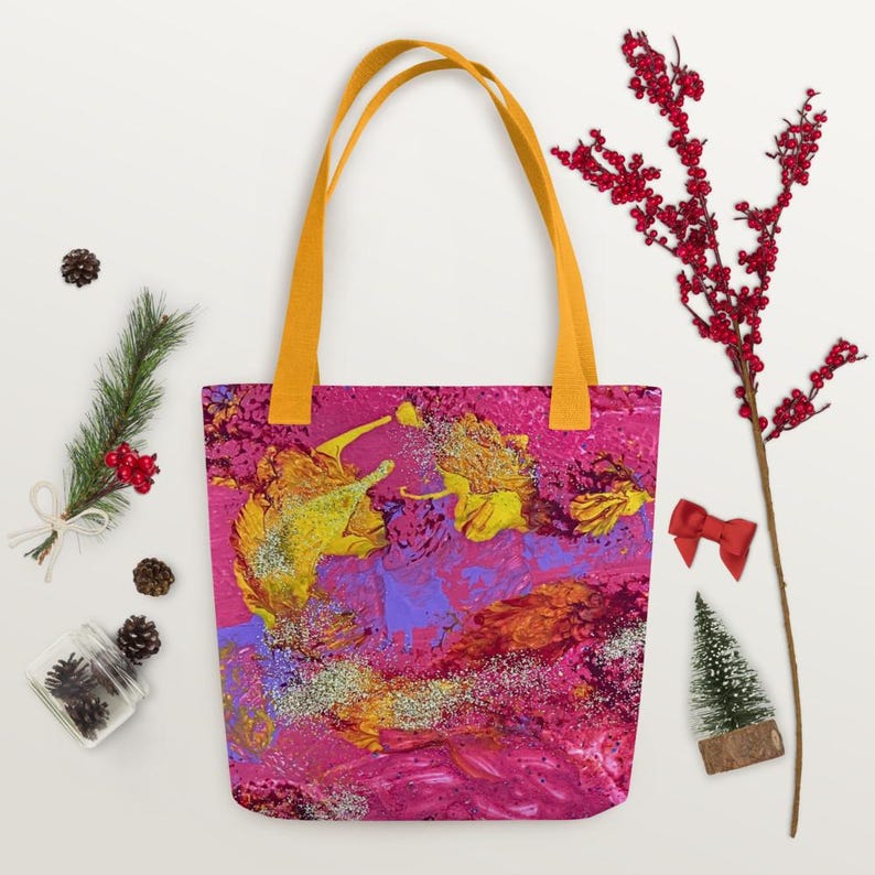 Może przedstawiać: Torba typu tote z żywym abstrakcyjnym wzorem w odcieniach r&oacute;żu, ż&oacute;łci i fioletu. Torba ma jaskrawoż&oacute;łte uchwyty. Grafika ma błyszczącą fakturę. Stylowy dodatek.