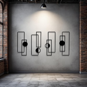 May include: Black metal wall art featuring geometric shapes, including rectangles and circles. The artwork is mounted on a gray wall in a room with a brick accent wall and a window. The design is modern and minimalist.