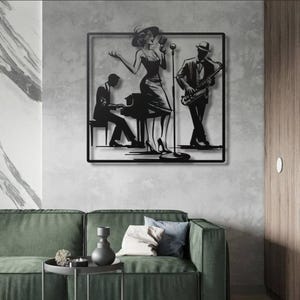 May include: Black metal wall art depicting a jazz band. A woman in a dress sings into a microphone, a man plays the saxophone, and another plays the piano. The art is framed in a black square and mounted on a gray wall.