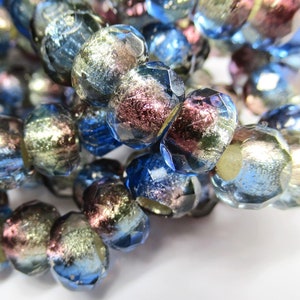 May include: A strand of iridescent glass beads with a mix of blue, silver, and pink hues. The beads have a faceted, slightly irregular shape.