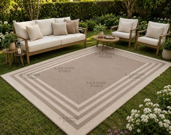 Tappeto minimalista con bordo geometrico, trapuntato a mano, in lana nei toni neutri del tortora e del crema.