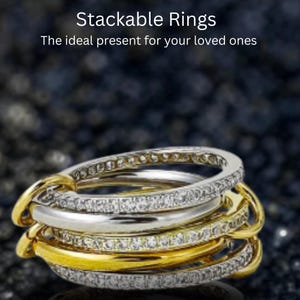 Pode incluir: Anéis empilháveis em ouro e prata. Um anel é prateado com pedras transparentes, e os outros anéis são dourados. A imagem tem o texto "Stackable Rings" e "The ideal present for your loved ones".