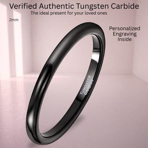 以下が含まれることがあります： 2mmの黒いタングステンカーバイド製リング。滑らかで光沢のある仕上げ。内側のバンドにはTUNGSTEN CARBIDEの刻印があります。画像にはVerified Authentic Tungsten CarbideおよびPersonalized Engraving Insideというテキストが含まれています。