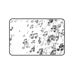 May include: A rectangular mousepad with a white background and a pattern of gray musical notes. The notes vary in size and density, creating a dynamic visual effect. The border of the mousepad is black.