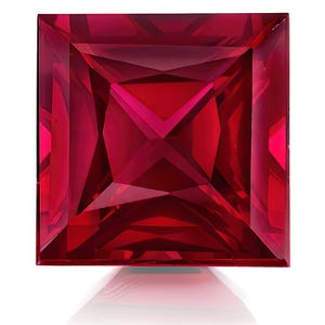 Può includere: Una gemma di rubino tagliata a forma quadrata e sfaccettata. La gemma è di un colore rosso intenso e saturo, con molteplici sfaccettature interne che riflettono la luce. La gemma è posta su uno sfondo bianco, con un sottile riflesso sottostante.