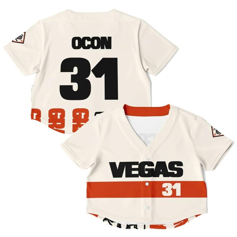 May include: Cream-colored baseball jersey with black lettering and the number 31. The jersey has a red stripe across the chest with the word "VEGAS" in black. A small logo is on the sleeve.
