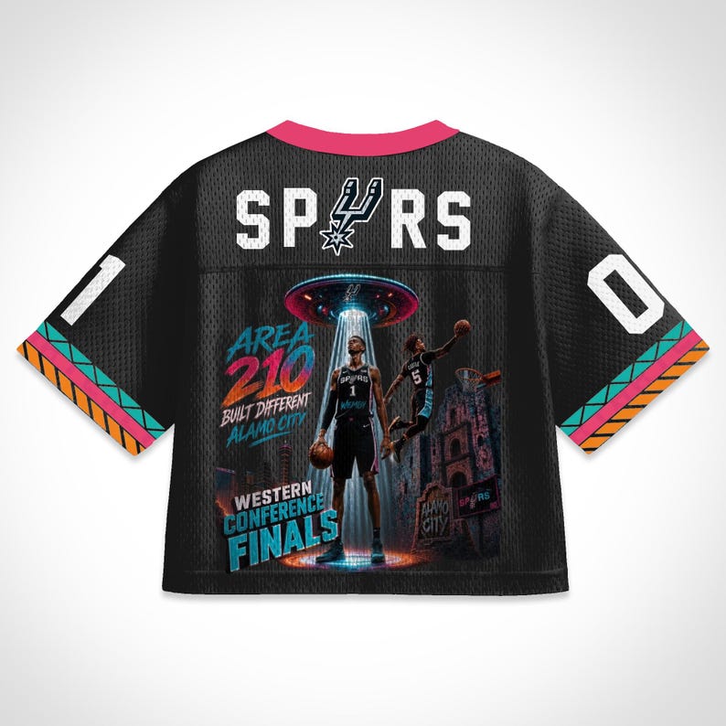 Op de afbeelding: Zwart mesh basketbalshirt met het woord "SPURS" in witte blokletters. Het shirt heeft een afbeelding van twee basketballers onder een UFO, met de tekst "AREA 210" en "WESTERN CONFERENCE FINALS". Het shirt heeft een roze kraag en kleurrijke afwerking.