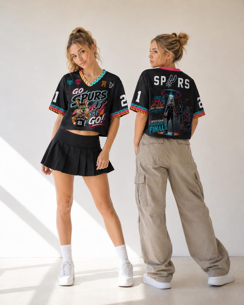 Op de afbeelding: Twee mensen dragen zwart-witte sportshirts met de tekst "GO SPURS GO!" en "SPURS" op de rug. De shirts hebben kleurrijke randen en afbeeldingen. E&eacute;n persoon draagt een zwarte geplooide rok, de ander een beige cargobroek.