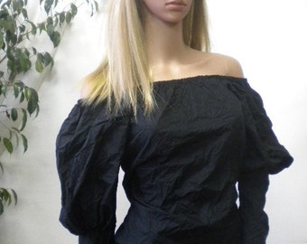 Black blouse of wrinkled cotton, bare shoulders, puffed sleeves.