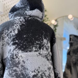 K&ouml;nnte beinhalten: Ein Set aus drei Keramikbechern mit gesprenkelter, matter Oberfl&auml;che. Die Becher sind in Creme-, Hellgrau- und Dunkelgraut&ouml;nen gehalten. Jeder Becher hat ein schlichtes, minimalistisches Design.