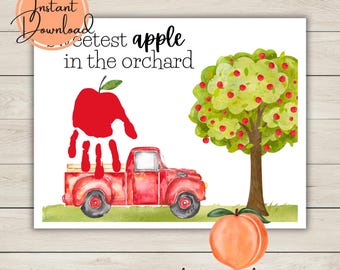 Puede incluir: Una impresión en acuarela con un camión rojo, un árbol cargado de manzanas rojas y un melocotón. El texto dice "sweetest apple in the orchard". Una manzana roja está formada por una huella de mano. Las palabras "Instant Download" y "hello peach prints" también son visibles.