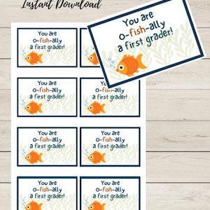 May include: Printable cards with the text "You are o-fish-ally a first grader!" and a cartoon goldfish. The cards have a white background with a blue border and are decorated with green seaweed. The words "Good Things Printables Instant Download" are at the top.