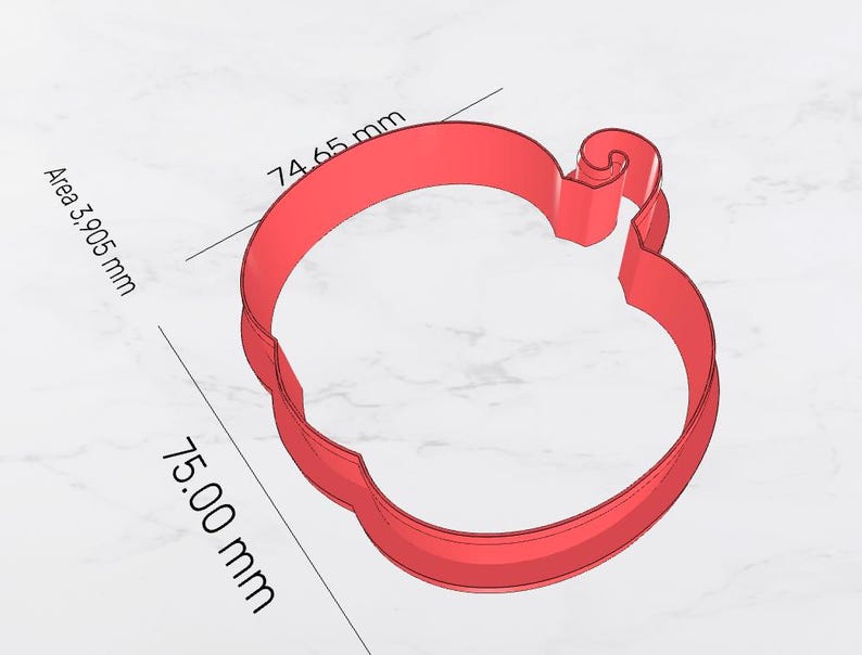May include: A red apple-shaped cookie cutter. The cutter is approximately 3 inches wide and 3 inches tall. The area is 3,905 mm. The apple has a stem and a curved top. The cutter is made of a solid material.
