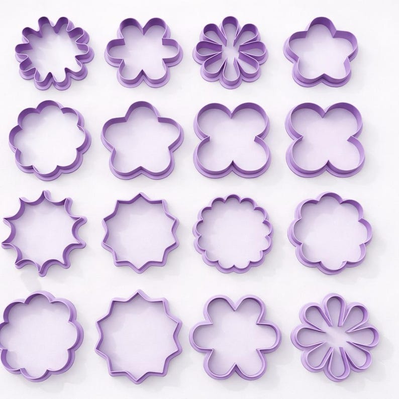May include: A collection of sixteen purple flower-shaped cookie cutters in various designs. The cutters are made of plastic and are arranged in a grid pattern. The shapes include starbursts, scalloped edges, and multi-petal flowers.