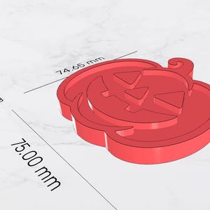 May include: A red, 3D-rendered pumpkin with a carved face, perfect for Halloween. The pumpkin measures 75.00 mm in length and 74.65 mm in width, with an area of 3,964 mm. The design features triangular eyes and a carved mouth.