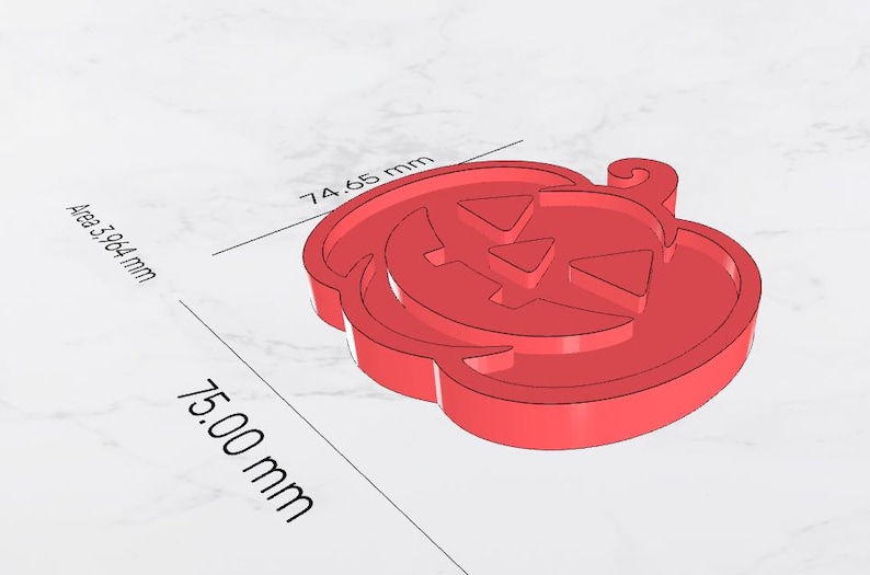 May include: A red, 3D-rendered pumpkin with a carved face, perfect for Halloween. The pumpkin measures 75.00 mm in length and 74.65 mm in width, with an area of 3,964 mm. The design features triangular eyes and a carved mouth.