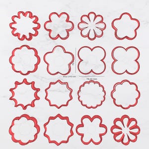 May include: A collection of red flower-shaped cookie cutters in various designs. The cutters are displayed on a white surface. The image includes measurements in millimeters, with one cutter measuring 74.65 mm.