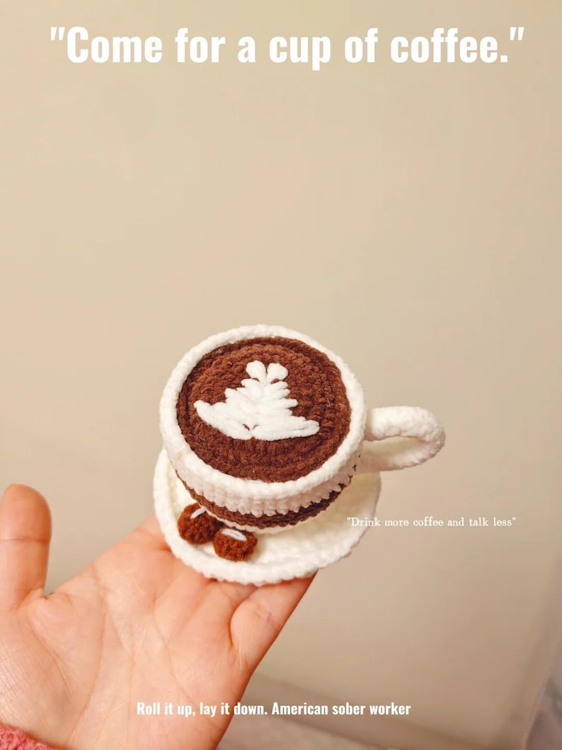 May include: A crocheted coffee cup and saucer. The cup is brown with a white leaf design and a white rim. The saucer has two small crocheted cookies. Text reads: "Come for a cup of coffee." and "Drink more coffee and talk less."