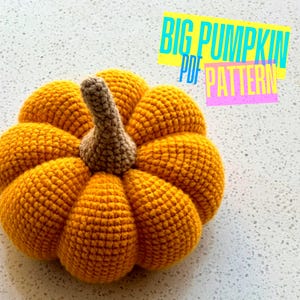 May include: A crocheted pumpkin in shades of orange with a brown stem. The pumpkin is made with a textured stitch, and the text "BIG PUMPKIN PDF PATTERN" is in the upper right corner.