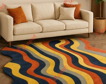May include: A colorful, wavy area rug with a modern design. The rug features stripes of navy blue, yellow, orange, and gray. The rug is placed on a hardwood floor in front of a beige sofa with orange and beige throw pillows.