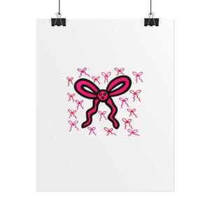 May include: A white poster featuring a cartoon bow design. The large bow is hot pink with a smiling face and wavy ribbons. Small pink bows are scattered around the main bow, all with black outlines. The poster is held by two black binder clips.