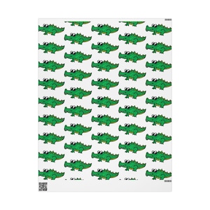May include: A white blanket with a repeating pattern of green cartoon alligators. Each alligator has black eyes and is outlined in black. The blanket is rectangular and appears to be made of a soft material.