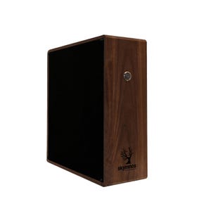 以下が含まれることがあります： 濃い木材仕上げと黒いフロントパネルを備えた長方形の木製スピーカー。小さなシルバーのノブが側面にあります。「skymnos」のブランド名と木のロゴが右下に印刷されています。