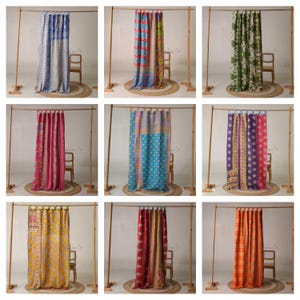 May include: Nine patterned curtains in various colours are displayed. Each curtain hangs from a wooden rod, showcasing designs such as blue with white dots, red and blue floral, green paisley, pink stripes, blue with polka dots, purple with gold accents, yellow stripes, burgundy, and orange.