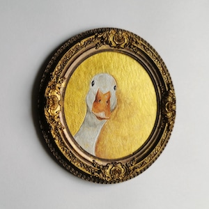 . Detailed acrylic portrait of a goose against a warm golden background, displayed in a handcrafted decorative bronze frame.