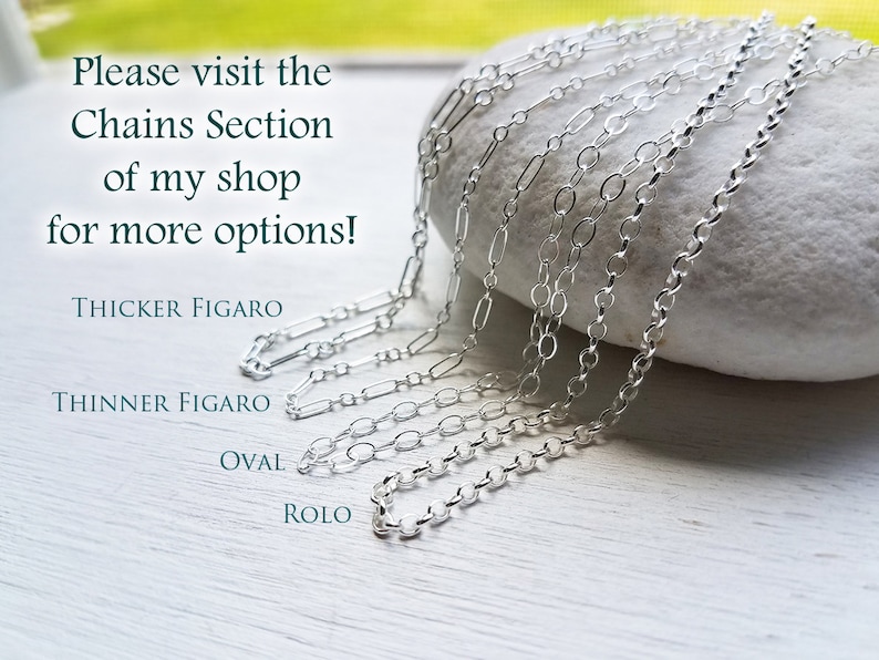 Puede incluir: Cinco tipos diferentes de cadenas de plata sobre una roca blanca. Las cadenas est&aacute;n etiquetadas como "Thicker Figaro", "Thinner Figaro", "Oval" y "Rolo".