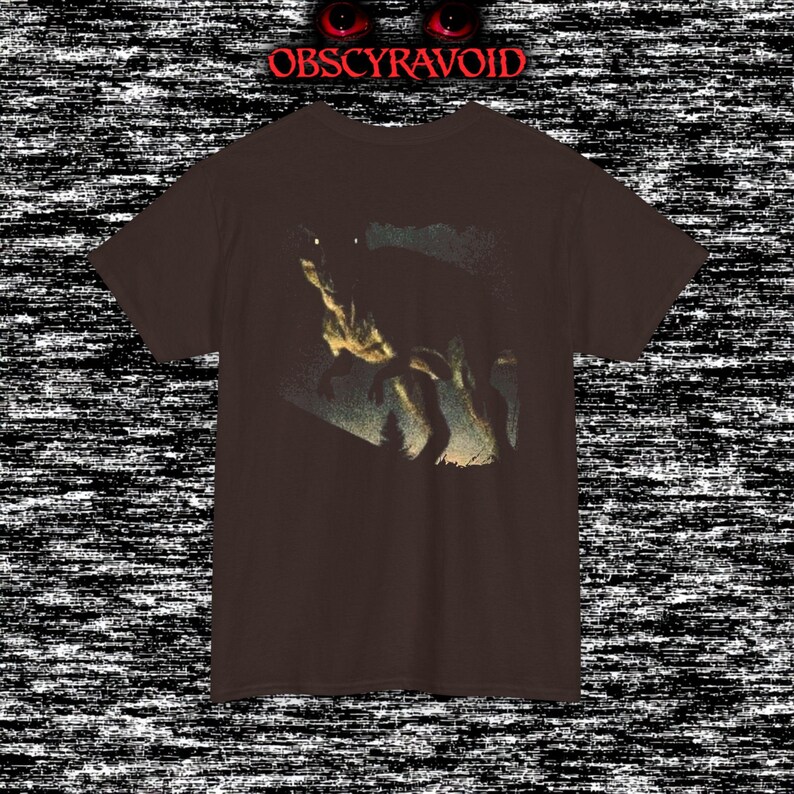 This analog horror–inspired T-shirt features a terrifying decayed dinosaur with human-like eyes and sharp teeth under the phrase “Something old is awake again.” The design combines VHS-style grain, eerie lighting, and vintage texture to create a haunting prehistoric horror vibe. Perfect for analog horror fans, dinosaur lovers, and retro-style collectors. Printed on high-quality fabric for lasting comfort and style.