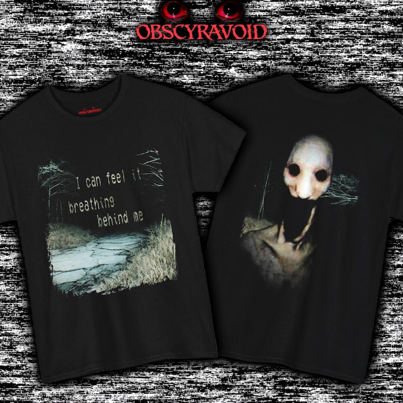 This unsettling front and back print t-shirt creates a full analog horror story. The front shows a grainy, desaturated forest path with the eerie text “I can feel it breathing behind me”, building tension through a quiet, abandoned atmosphere. The back reveals the source of the fear: a pale, distorted creature with hollow black eyes and an unnaturally wide mouth emerging from darkness. The VHS-style texture and creepy forest setting make this design perfect for fans of psychological horror.