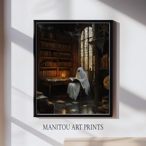 May include: A framed art print depicts a ghost reading in a library. The ghost is draped in a white sheet, seated in a wooden chair, and illuminated by candlelight. Bookshelves line the walls, and the text "MANITOU ART PRINTS" is at the bottom.