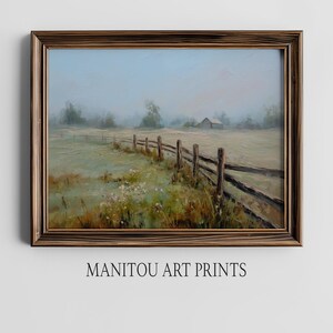 May include: A framed landscape painting shows a rural scene with a wooden fence, a field, and a barn in the distance. The artwork uses a muted colour palette of greens, browns, and blues, with the text "MANITOU ART PRINTS" at the bottom.