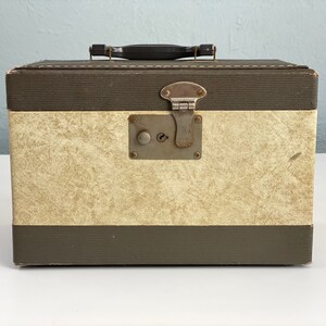 May include: A vintage brown and cream suitcase with a metal latch and a black handle.
