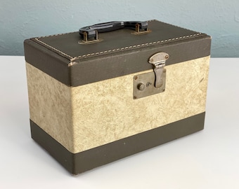 May include: A vintage brown and beige suitcase with a black handle and a metal latch. The suitcase has a textured fabric exterior.