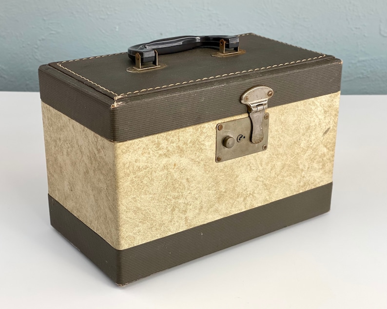 May include: A vintage brown and beige suitcase with a black handle and a metal latch. The suitcase has a textured fabric exterior.