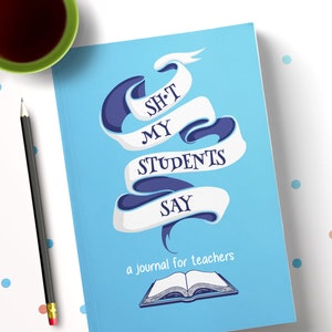 May include: A light blue journal titled "SH*T MY STUDENTS SAY" with a banner design. The journal is for teachers and features an open book illustration. A cup of tea and a pencil are on the side.