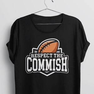 May include: Black t-shirt with a white graphic of a football and the text "Respect the Commish".