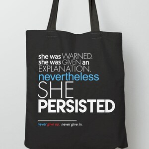 May include: Black tote bag with white and blue text that reads "she was WARNED. she was GIVEN an EXPLANATION. nevertheless SHE PERSISTED" and "never give up. never give in."