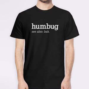 K&ouml;nnte beinhalten: Schwarzes T-Shirt mit dem wei&szlig;en Wort "humbug" und dem darunter gedruckten Text "see also: bah.". Das T-Shirt hat einen Rundhalsausschnitt.
