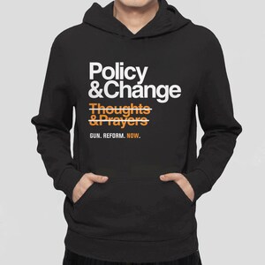 May include: Black hoodie with a white graphic that says "Policy & Change" with a line through "Thoughts & Prayers" and the text "GUN. REFORM. NOW."