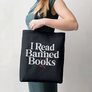 May include: A black tote bag with white text that reads "I Read Banned Books" and a small red devil illustration.