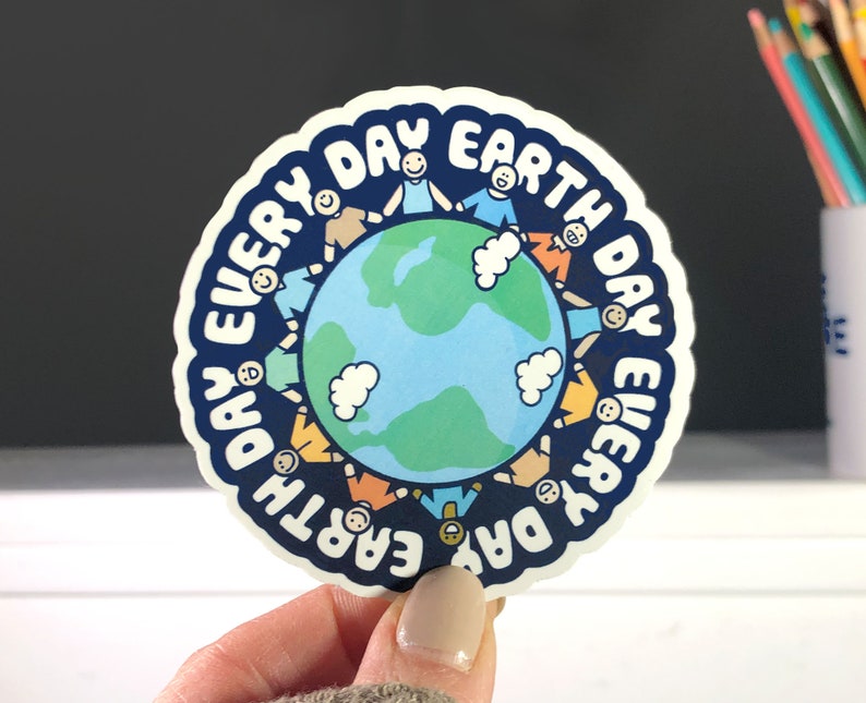 Puede incluir: Una pegatina azul y blanca con el texto "Every Day Earth Day" en un c&iacute;rculo alrededor de una imagen de dibujos animados de la Tierra con personas d&aacute;ndose la mano alrededor.
